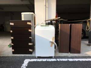 粗大ごみ置き場に並べられたタンスや洗濯機などの不用品の写真